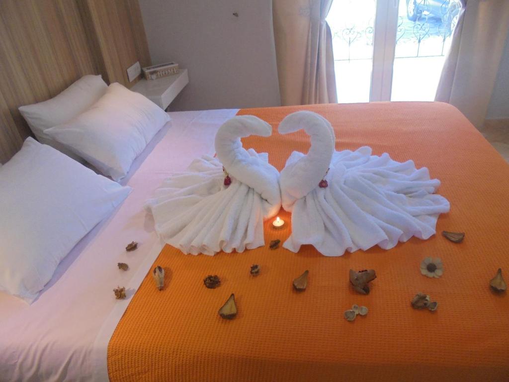 two white swans making a heart on a bed at Ourania Studios in Sami