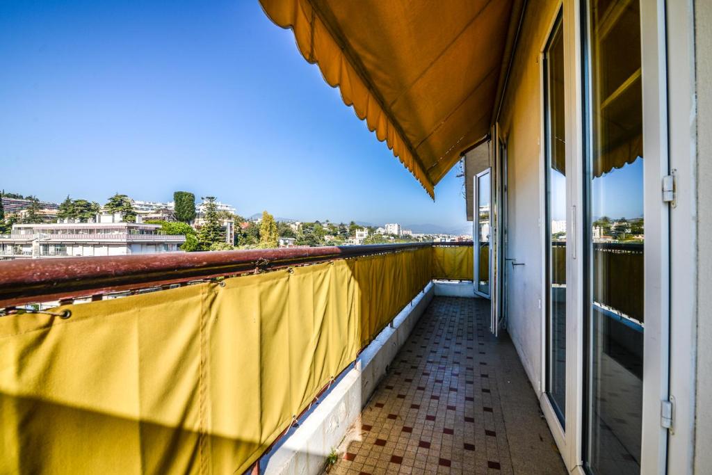 ニースにあるAppartement moderne à 2 min de la plage - 6 persの建物内の黄色いカーテン付きバルコニー