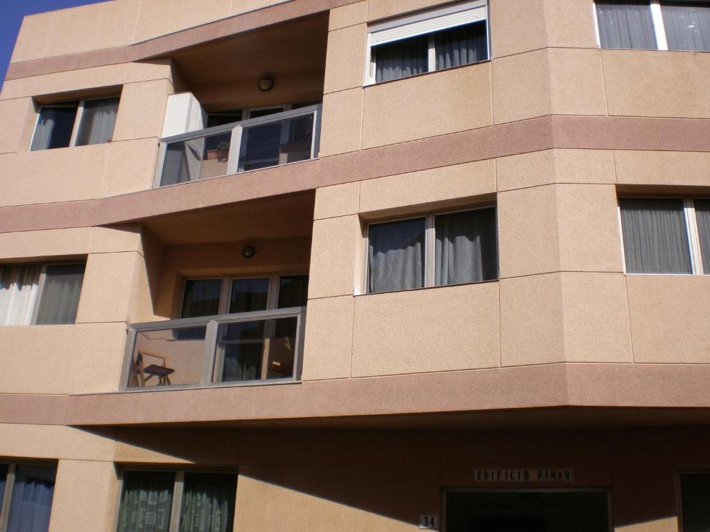 een hoog gebouw met ramen aan de zijkant bij A Un Paso Del Mar in Arinaga