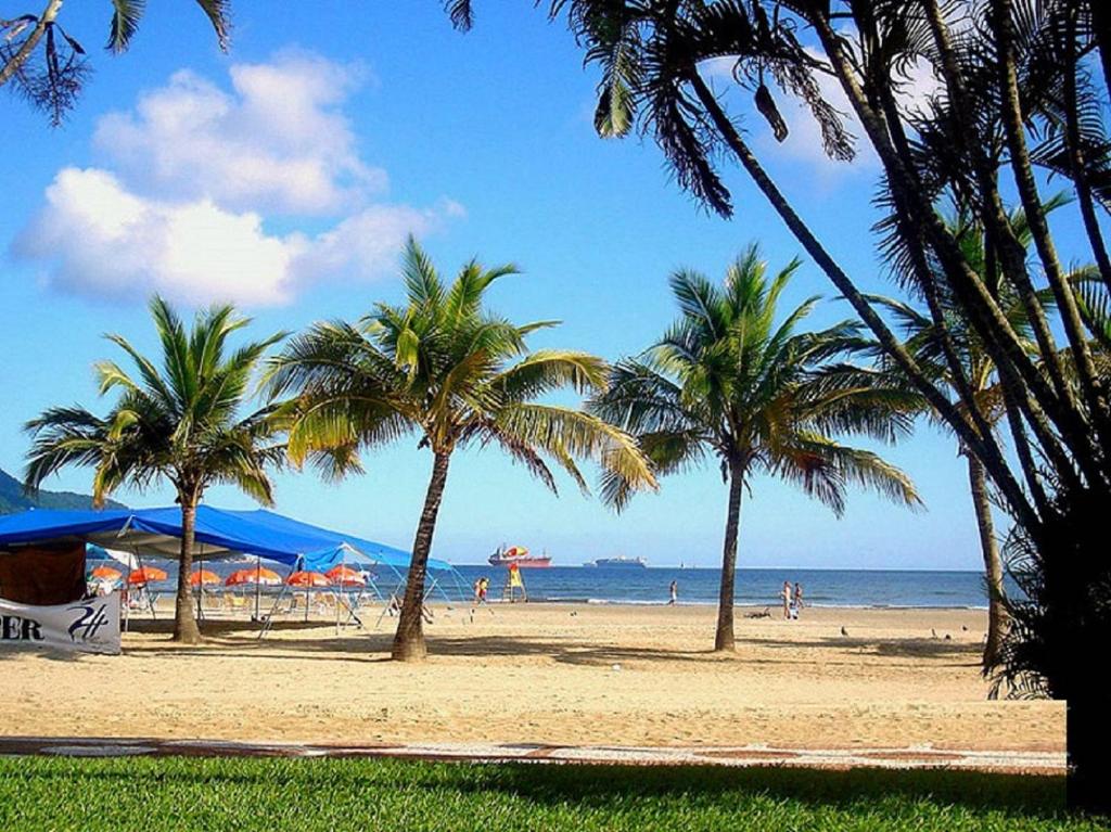 una playa con palmeras y gente en la playa en Praia Palace en Santos