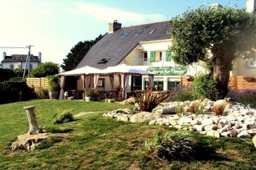 una casa con un jardín de rocas en el patio en Auberge An Douar, en Quéven