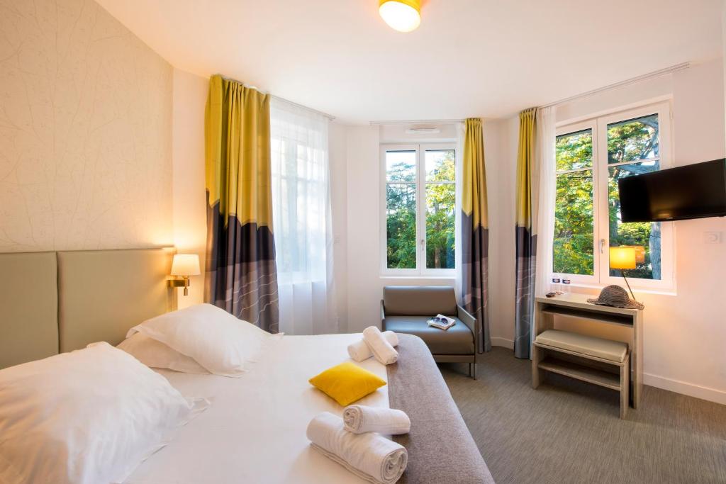 Un dormitorio con una cama, una silla y un escritorio. en Villa Bettina, en La Baule