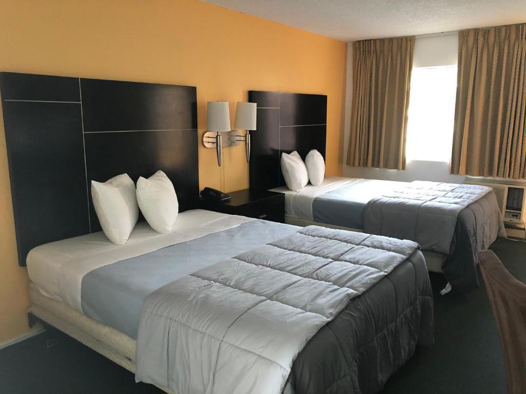 ein Hotelzimmer mit 2 Betten und weißen Kissen in der Unterkunft Desert Lodge in Palm Springs