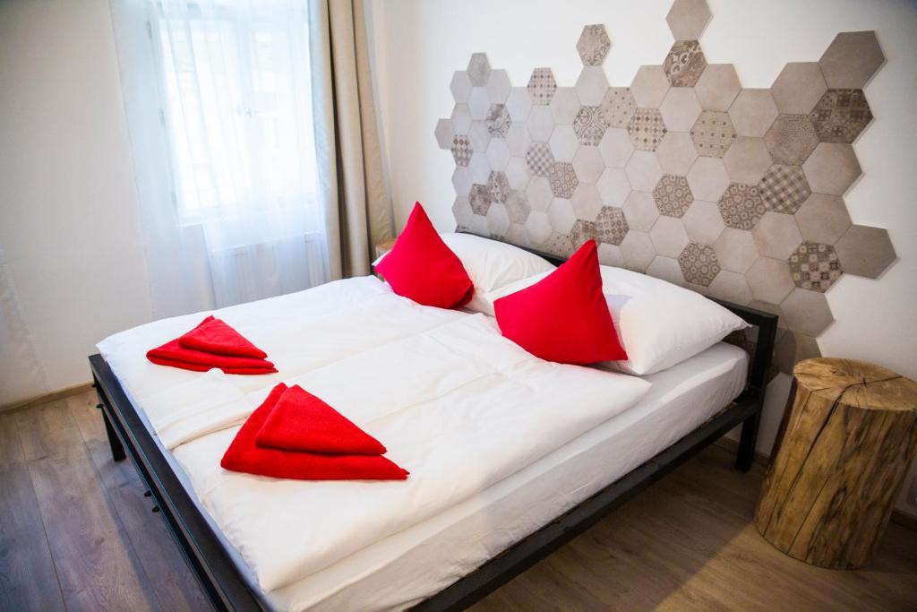 a bed with red pillows on it in a room at Gregory House in Prague