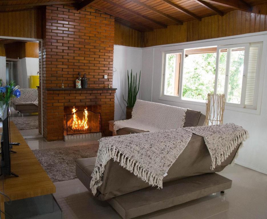 a living room with a couch and a fireplace at Residencia Hencke Haus in Canela