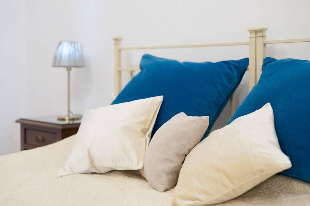 uma cama com almofadas brancas e almofadas azuis em Love weekend near Piazza Ognissanti em Florença