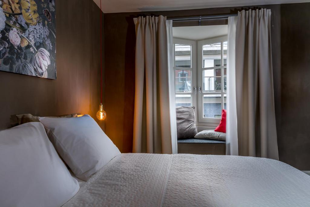 een slaapkamer met een wit bed en een raam bij Zoet Valkenburg in Valkenburg