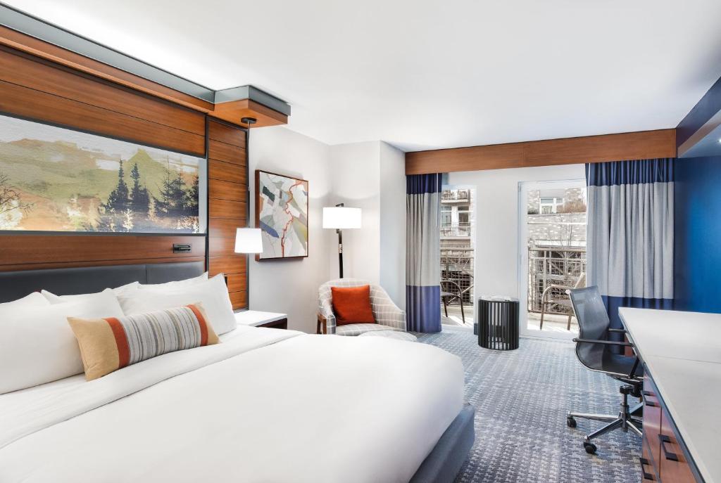 カークランドにあるザ　ヒースマン　ホテル　カークランドのベッドとデスクが備わるホテルルームです。