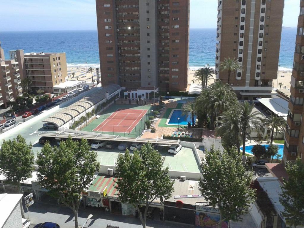 una pista de tenis en una ciudad con el océano en Apartment caballos levante beach en Benidorm