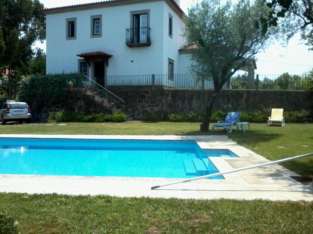 a house and a swimming pool in front of a house at Casa Maria Joana in Ponte de Lima
