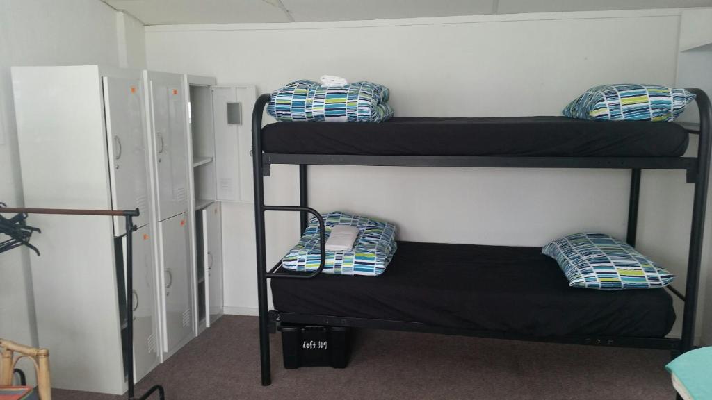 a room with three bunk beds with pillows on them at Loft 109 Backpackers Hostel in Tauranga