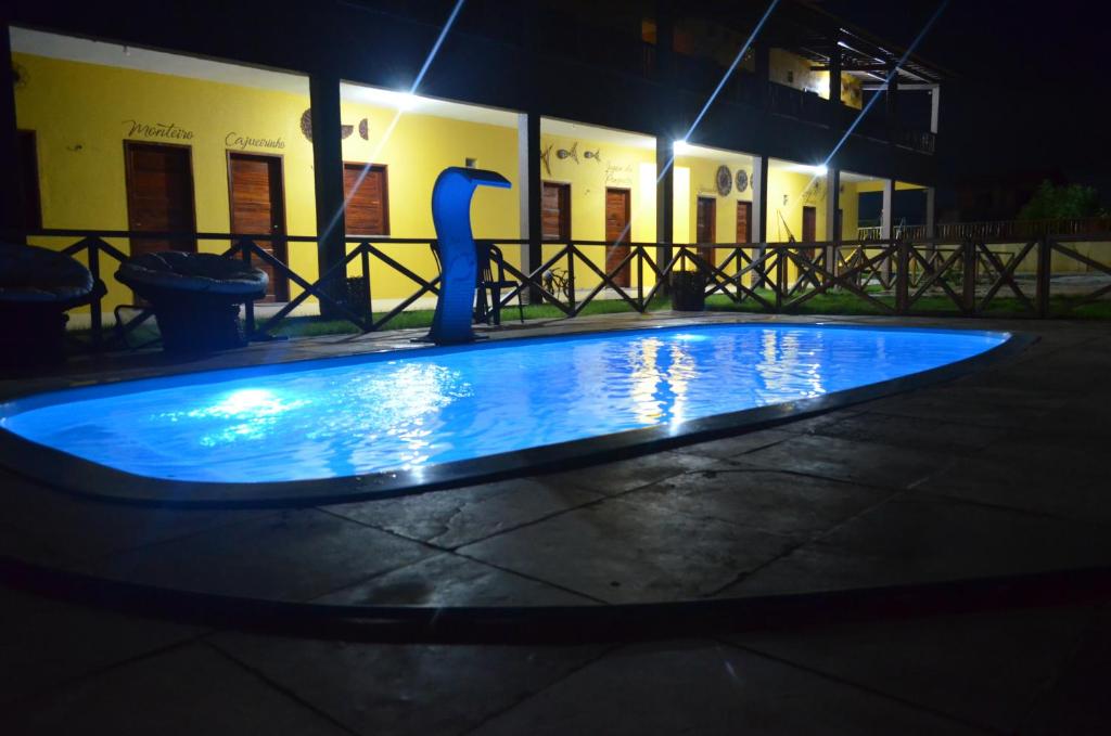 a blue pool in front of a building at night at Pousada Vila Mariana in Prea