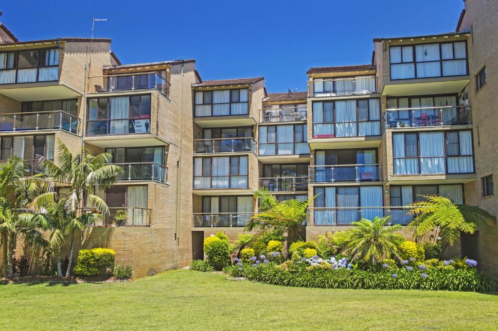 an apartment building with a lawn in front of it at Beachpark 56 58 Pacific Drive in Port Macquarie