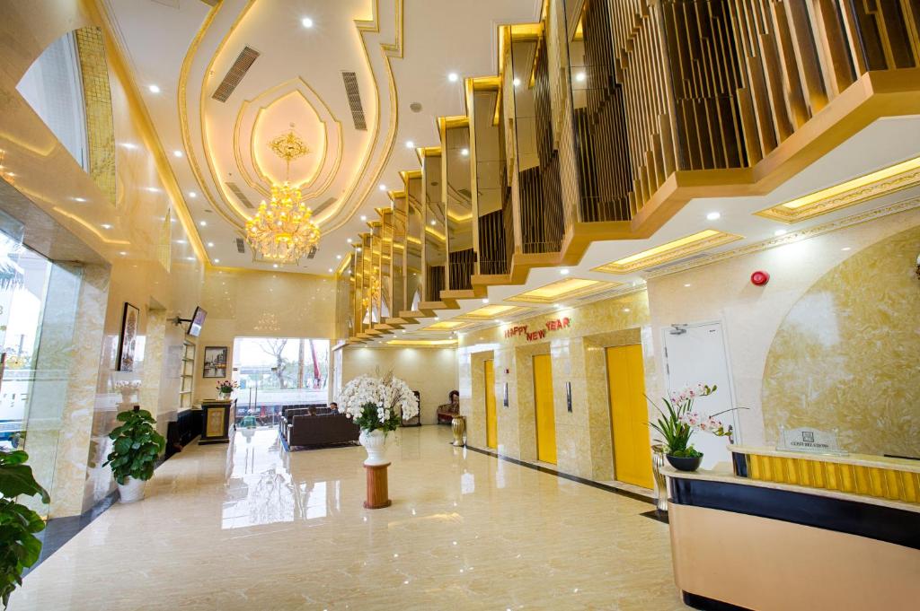 A grand lobby features marble finishes, illuminated ceilings and a broad staircase.