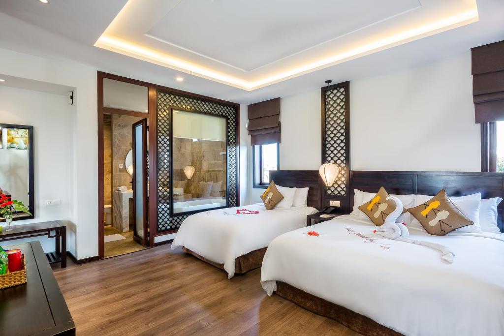 Postel nebo postele na pokoji v ubytování Hoi An Emotion Boutique Villa