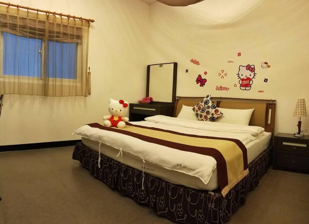 a bedroom with two beds and a teddy bear sitting on the bed at Rice Countryside in Dongshan