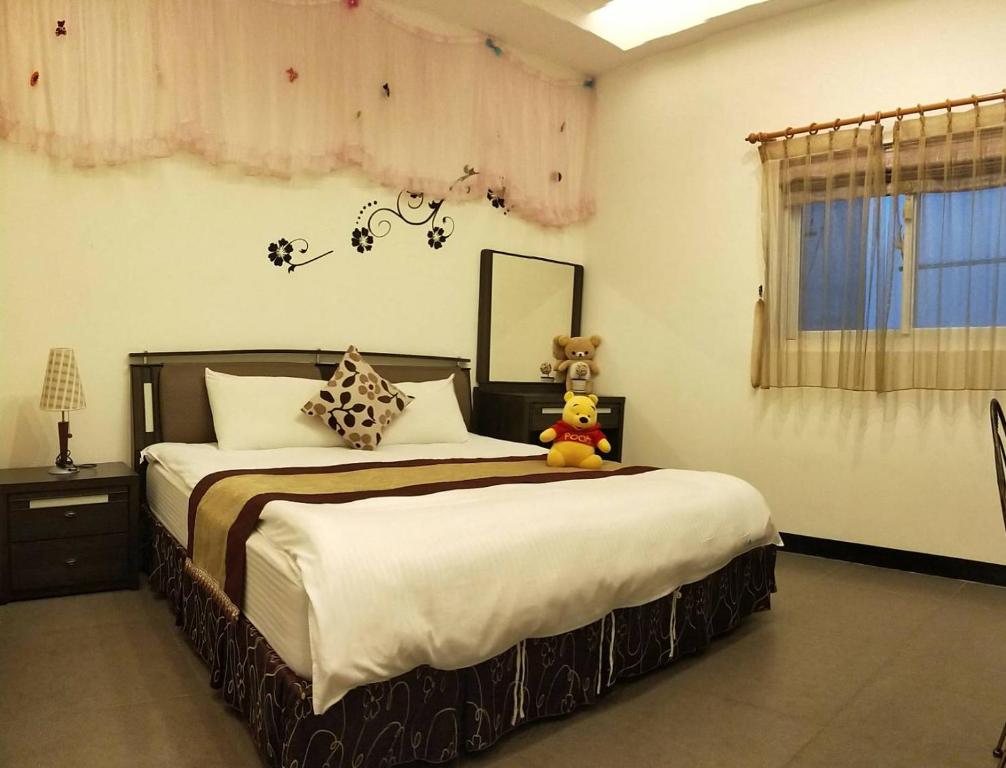 a bedroom with a bed with a teddy bear sitting on it at Rice Countryside in Dongshan