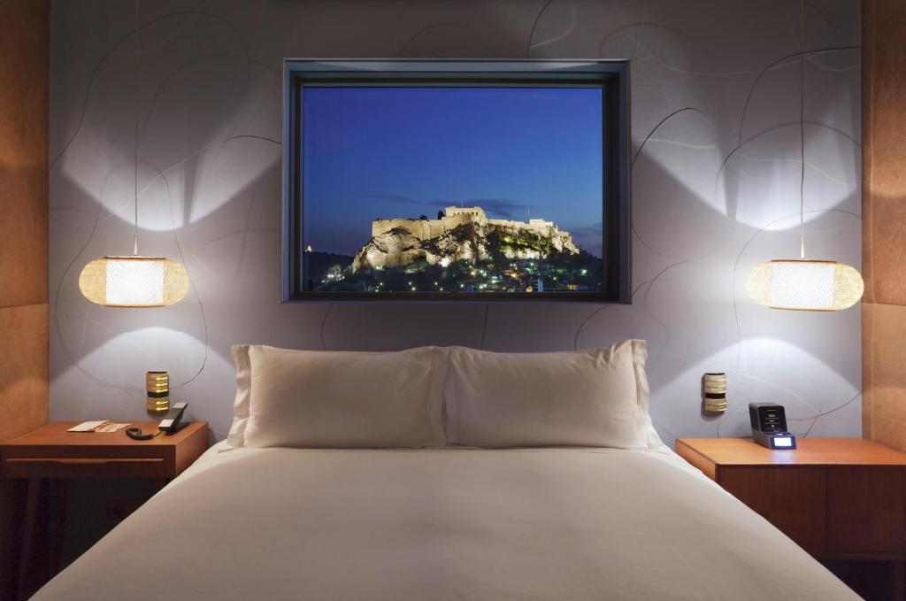 
a bedroom with a bed, television and a painting on the wall at New Hotel in Athens
