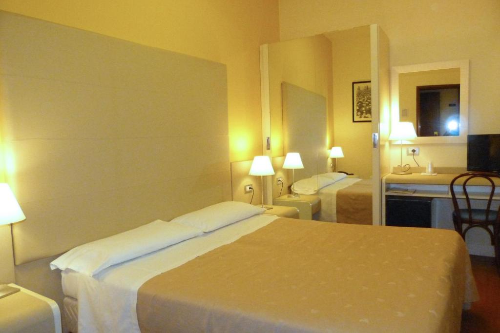Postel nebo postele na pokoji v ubytování Hotel Centrale Byron