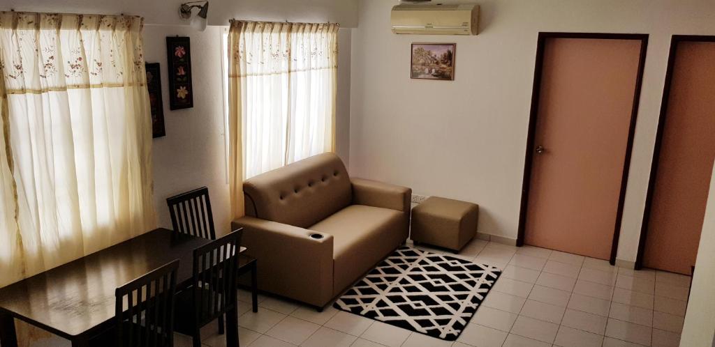 Basic & Cozy Home في بايان ليباس: غرفة معيشة مع كرسي وطاولة