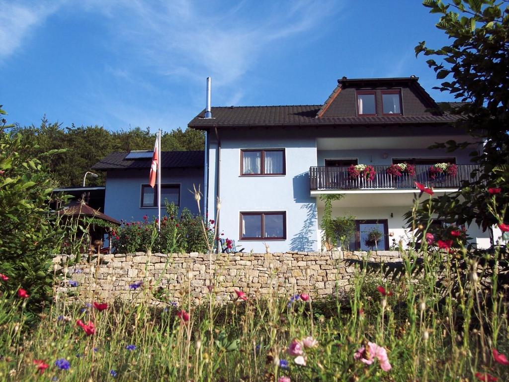una casa blanca con una valla y flores en Ferienwohnung Patricia Schipper, en Gemünden
