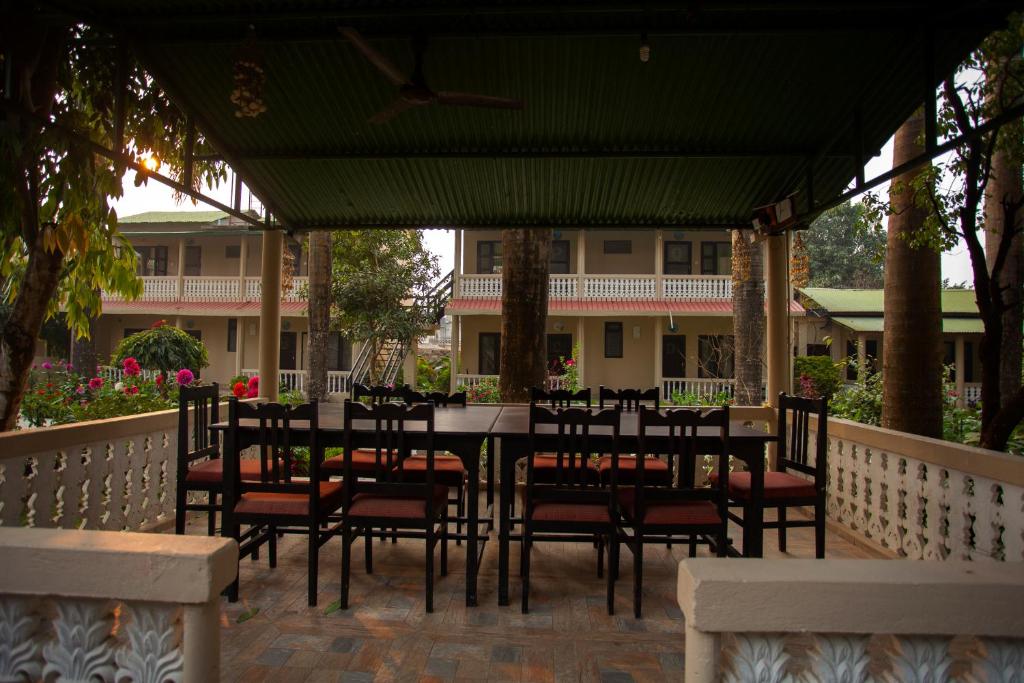 a patio with a table and chairs under a pergola at Sauraha Resort in Sauraha