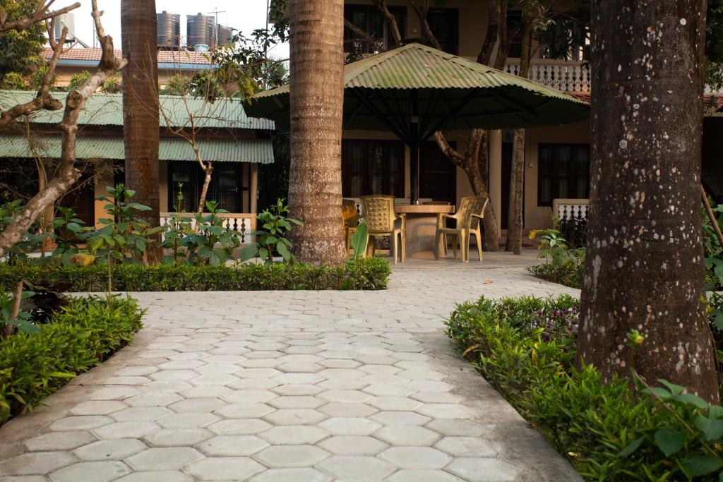 a patio with an umbrella and a table and chairs at Sauraha Resort in Sauraha