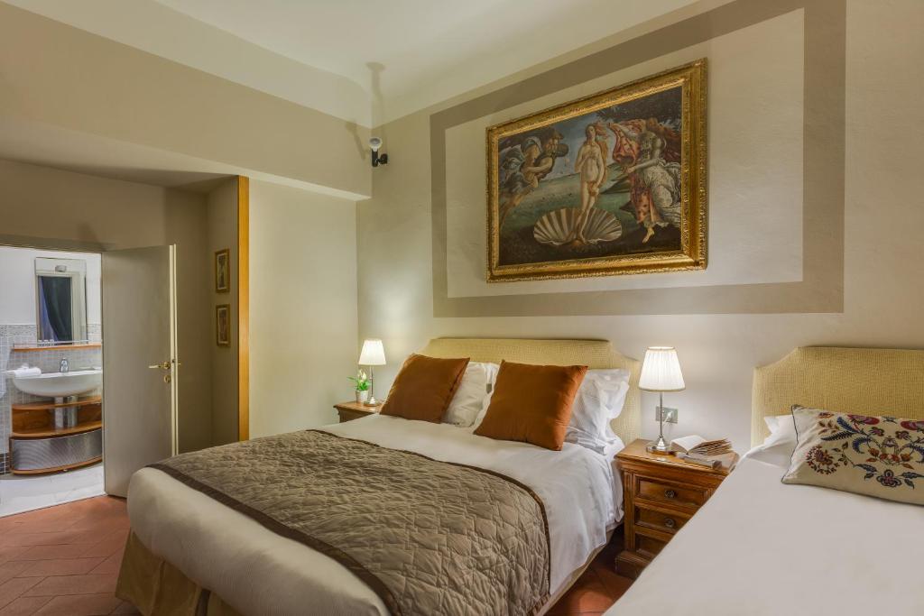 Łóżko lub łóżka w pokoju w obiekcie Locanda Dei Guelfi