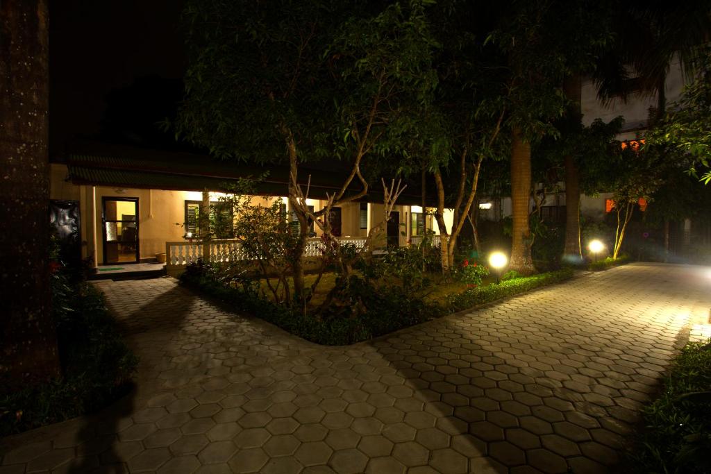 a night view of a walkway with trees and a building at Sauraha Resort in Sauraha
