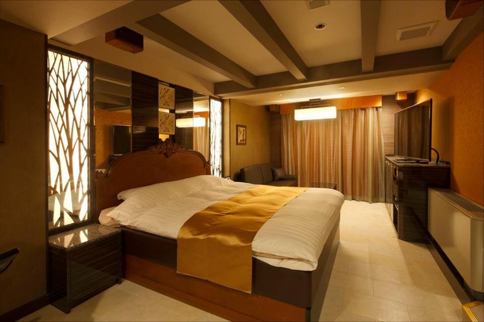 Hotel Waltz Chiryu (Adult Only) في Chiryu: غرفة نوم بسرير كبير وتلفزيون