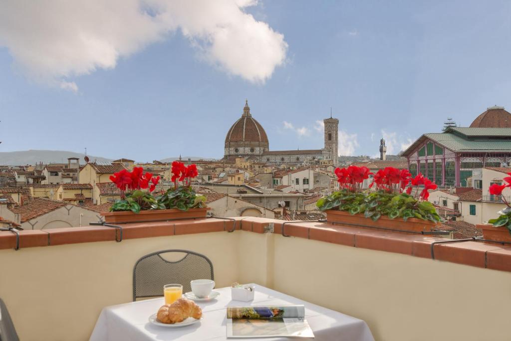 a table on a balcony with a view of a city at Locanda Dei Guelfi in Florence