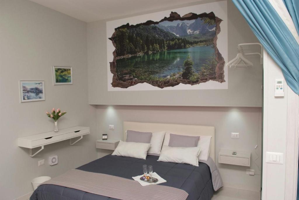 - une chambre avec un lit orné d'une peinture murale dans l'établissement Cataleya, à Catane