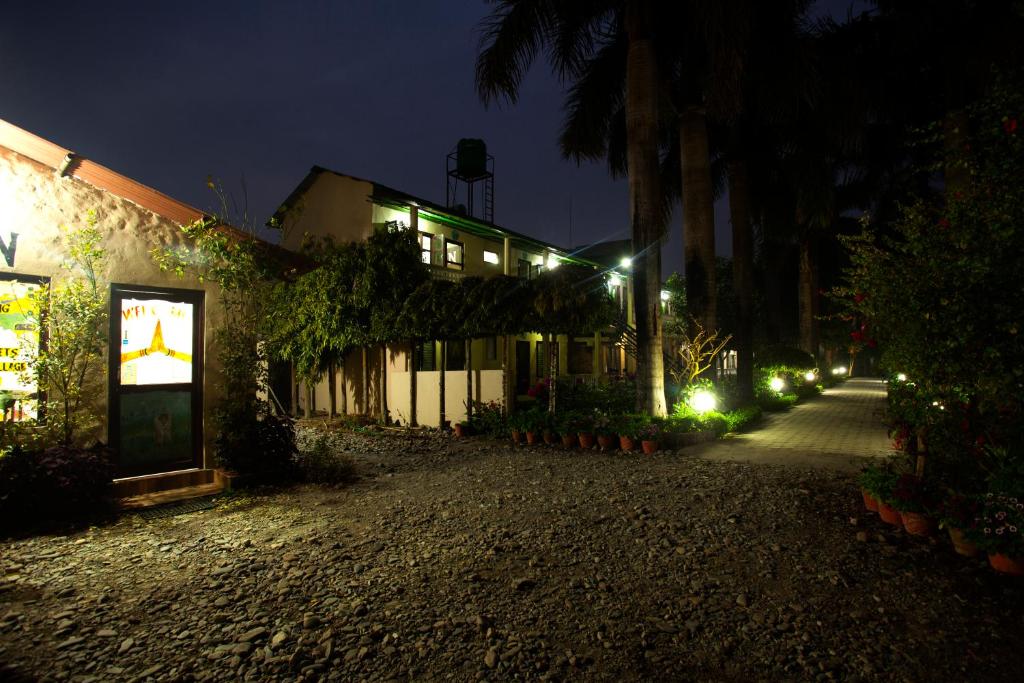an empty street at night with a building with lights at Sauraha Resort in Sauraha