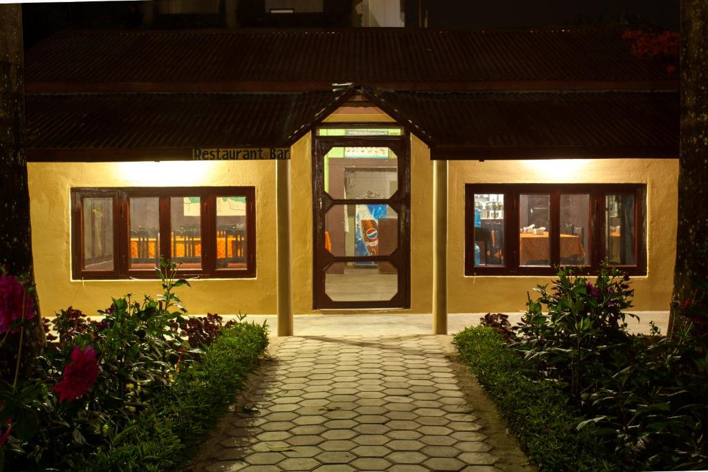 a yellow building with a door and a walkway at Sauraha Resort in Sauraha