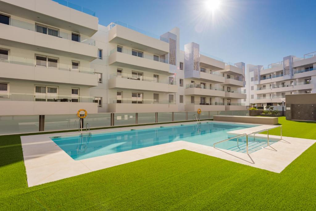 a swimming pool in front of a building at Aqua Apartments Vento, Marbella in Marbella