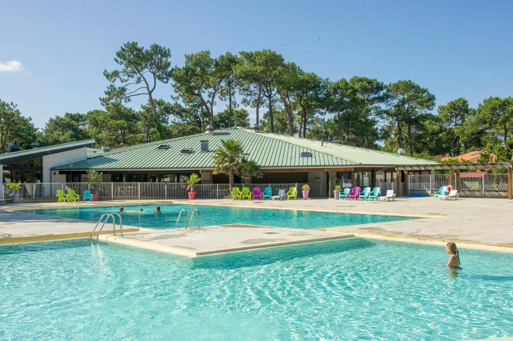 a pool at a resort with a person in the water at VTF La Jaougue Soule in Biscarrosse-Plage