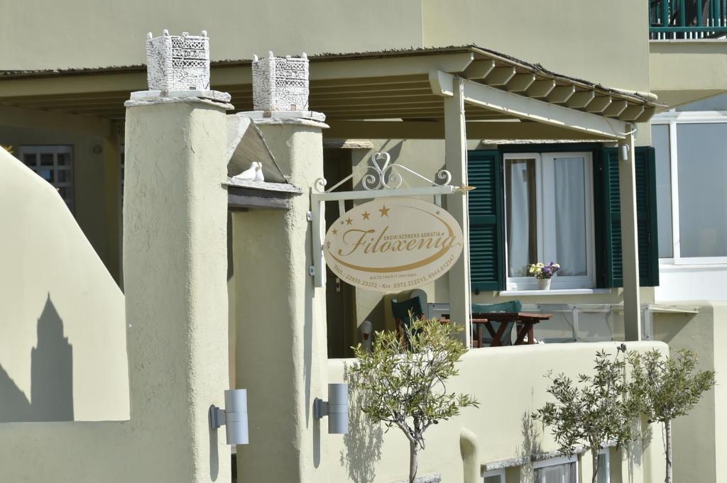 ein Schild für ein Restaurant an der Seite eines Gebäudes in der Unterkunft Filoxenia in Tinos