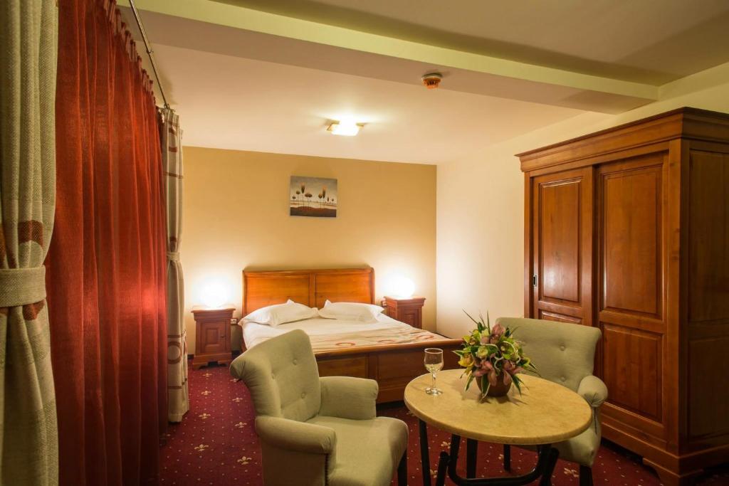 um quarto de hotel com uma cama, uma mesa e cadeiras em Red Hotel em Alexandria