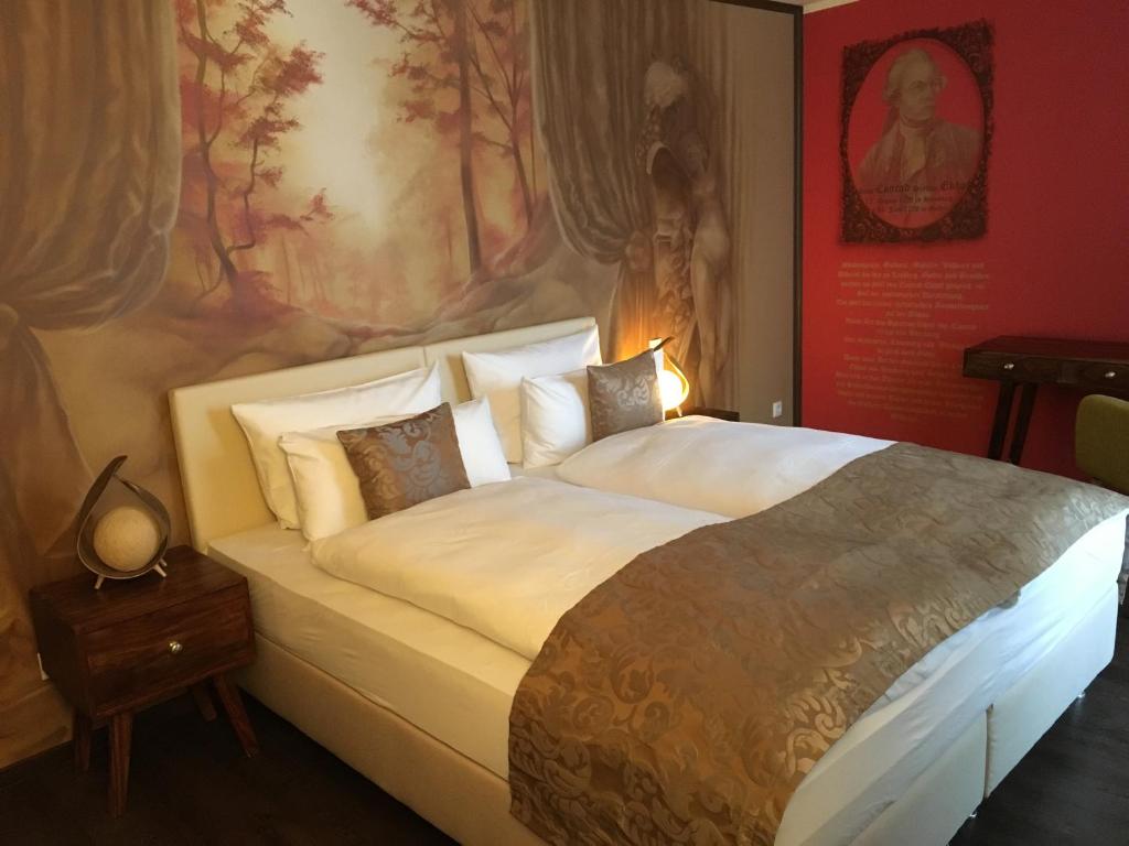 a bedroom with a large bed with a painting on the wall at Gästehaus Luise in Gotha