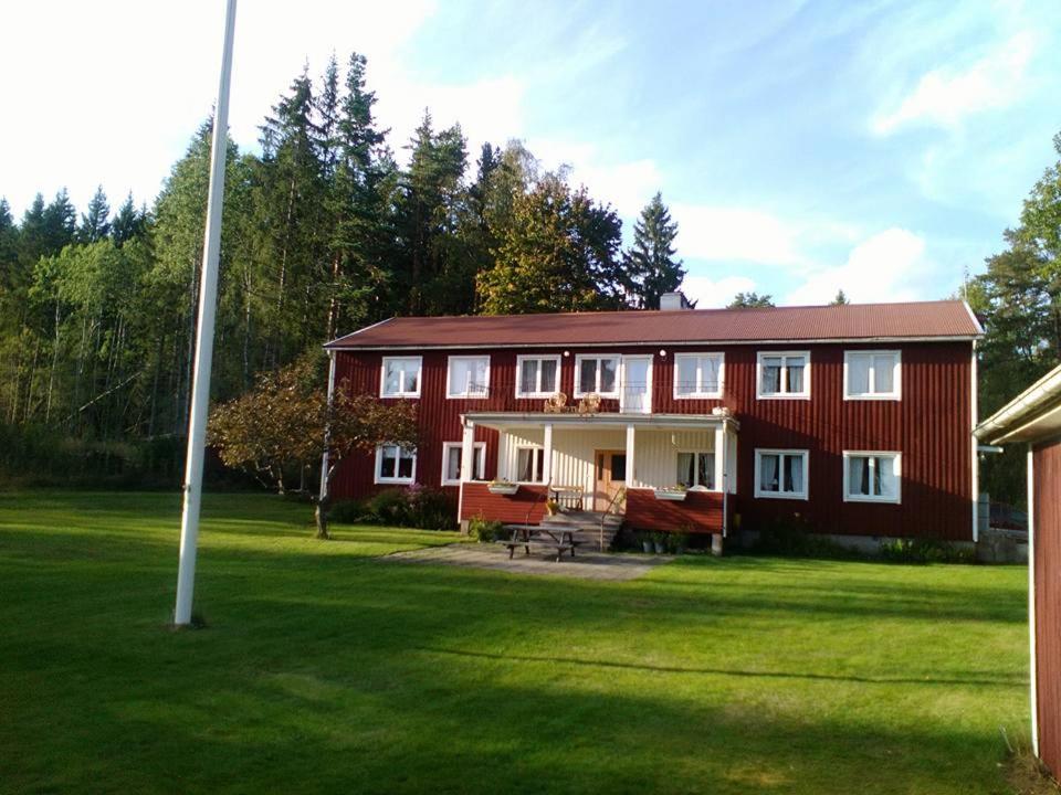 una gran casa roja con un gran patio en Vekhyttegården, en Fjugesta