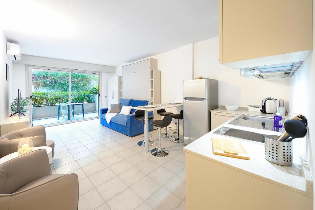 een keuken en een woonkamer met een bureau en een bank bij Silvia degli Aregai in Santo Stefano al Mare