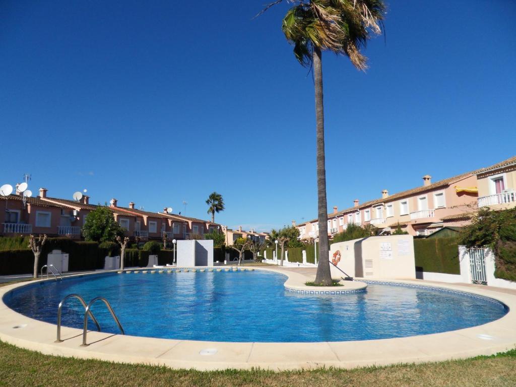 una piscina con una palma al centro di Casa Mandarina a Els Poblets
