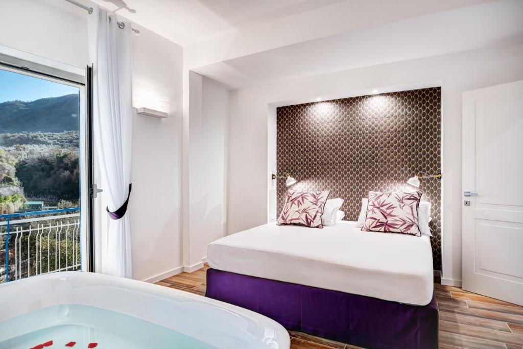- une chambre avec une baignoire, un lit et une fenêtre dans l'établissement Caruso 6, à Sorrente