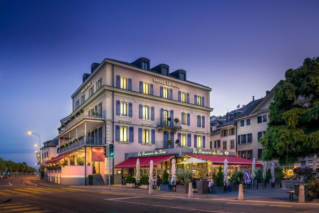 a large building on the corner of a street at Hotel Le Rive in Nyon