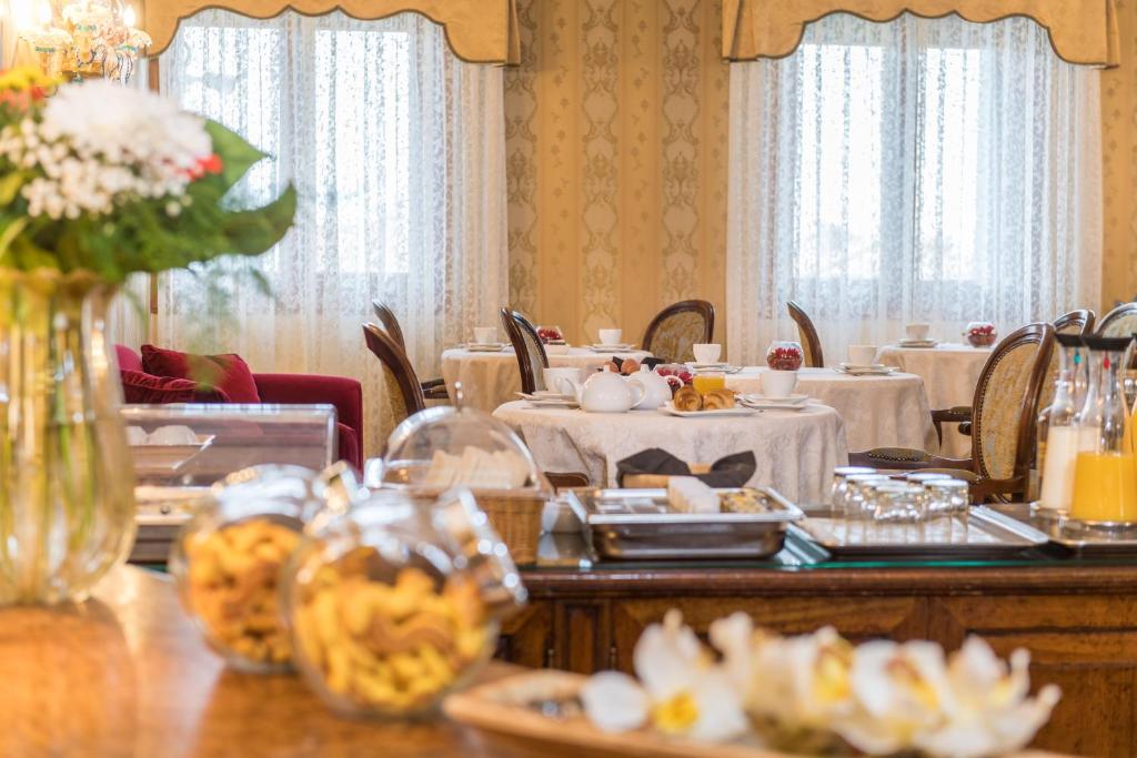 a dining room with a table with plates of food at Palazzo Bembo - Exclusive Accommodation in Venice