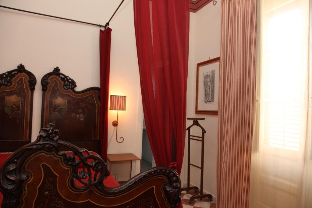 a bedroom with a bed and red curtains at B&B Casa Ruffino in Balestrate