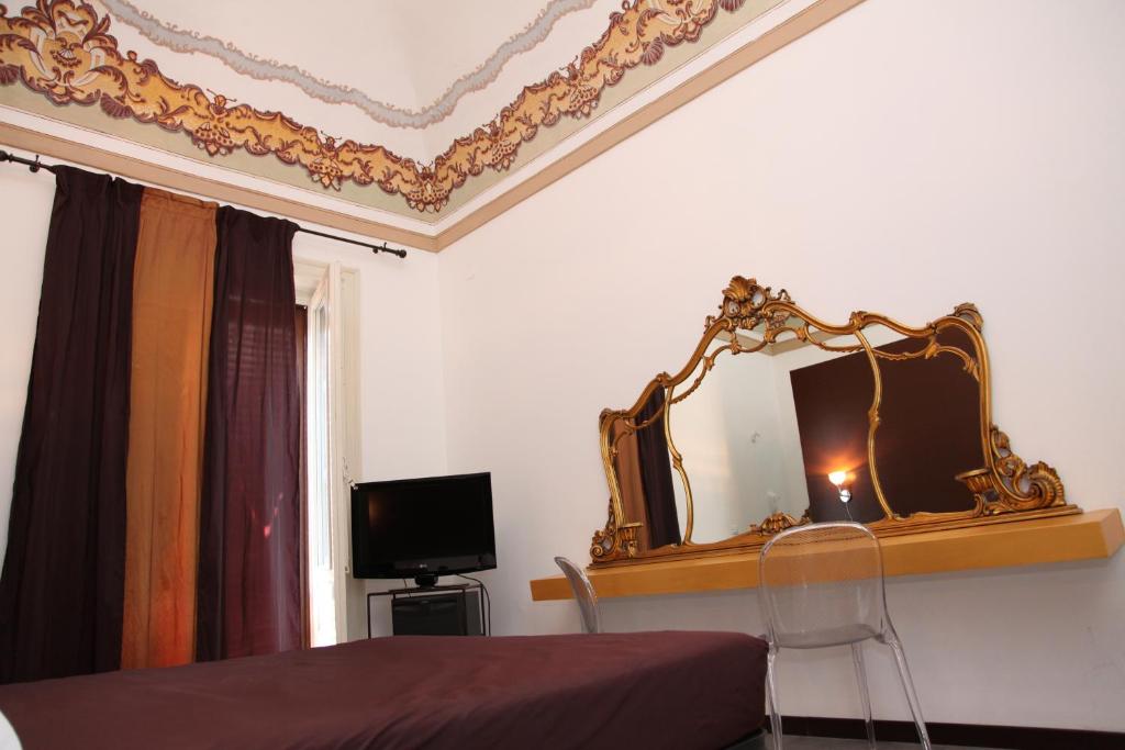 a bedroom with a bed and a mirror on the wall at B&B Casa Ruffino in Balestrate