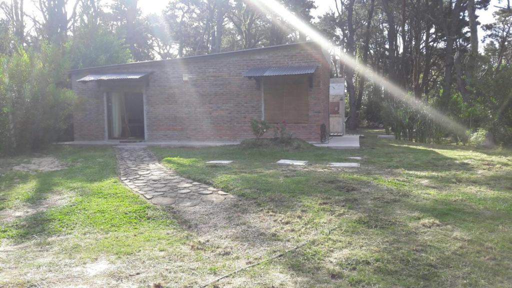 una pequeña casa de ladrillo en un patio con un rayo de luz en Los Superabuelos, en La Pedrera