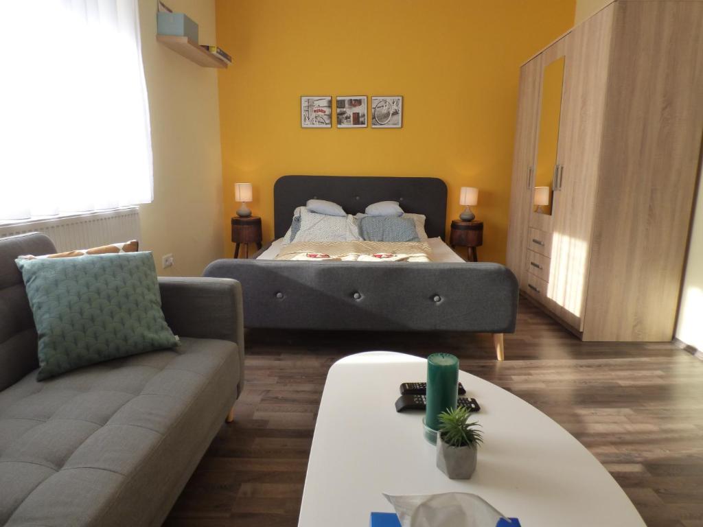 een woonkamer met een bed en een bank bij Yellow Apartment in Debrecen
