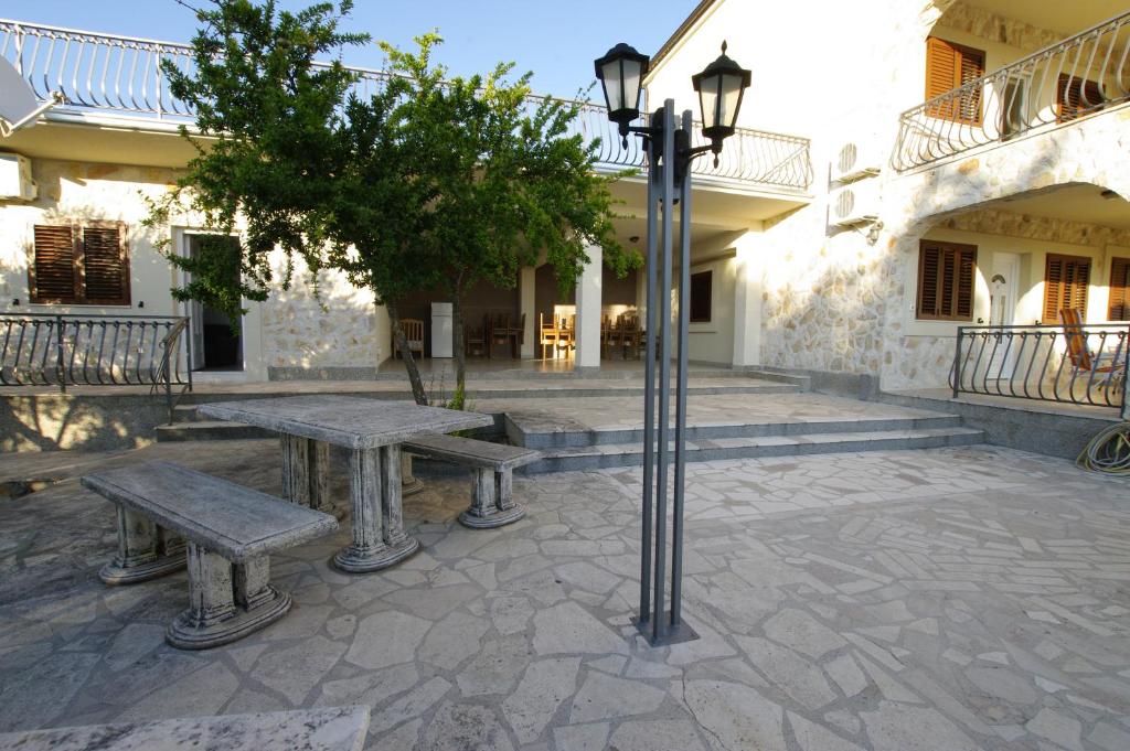 a courtyard with two benches and a street light at Murter Inn in Murter